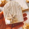 Surf board print cookie with sea shells, sand and starfish